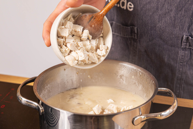 Hähnchenwürfel zur Sauce geben