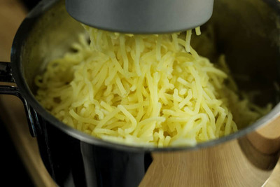Kartoffeln durch Kartoffelpresse drücken
