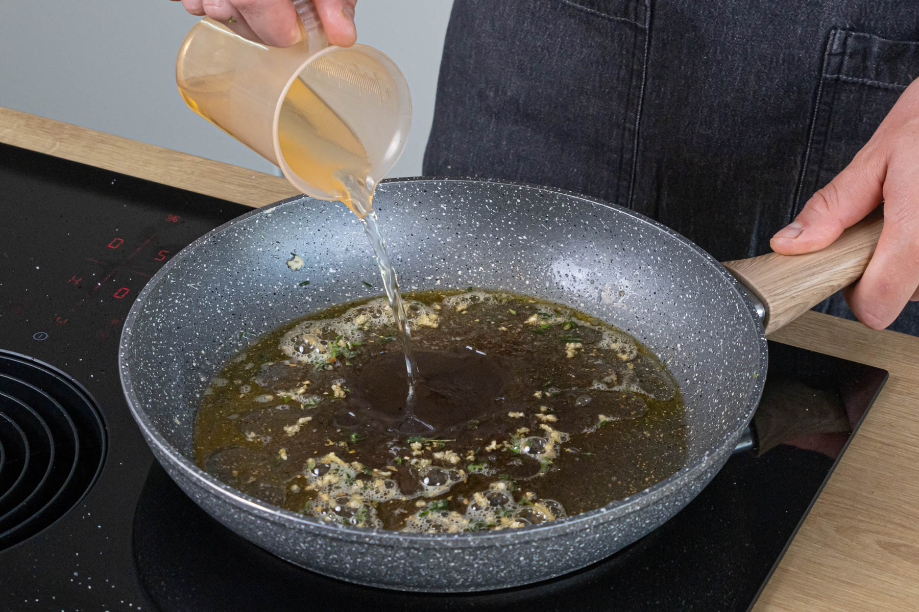Weißwein und Brühe in die Pfanne gießen