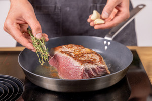 Kräuter und Knoblauch mit in die Pfanne geben