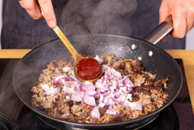 Tomatenmark, Zwiebeln und Gewürze mitbraten