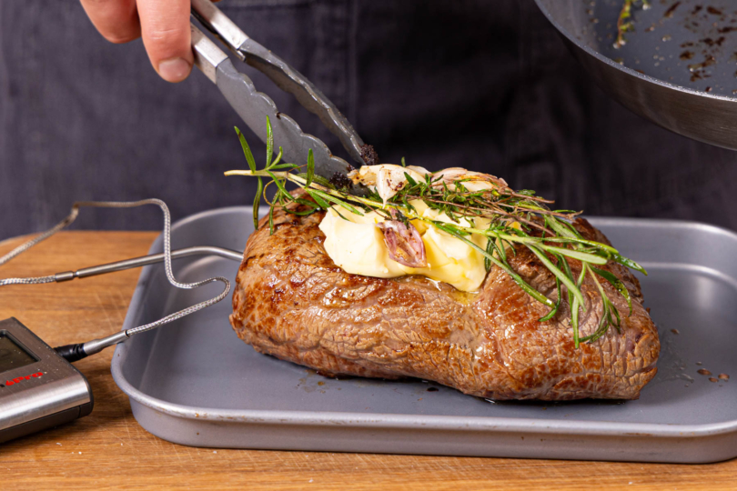 Butter und Kräuter auf das Fleisch legen und im Ofen garen