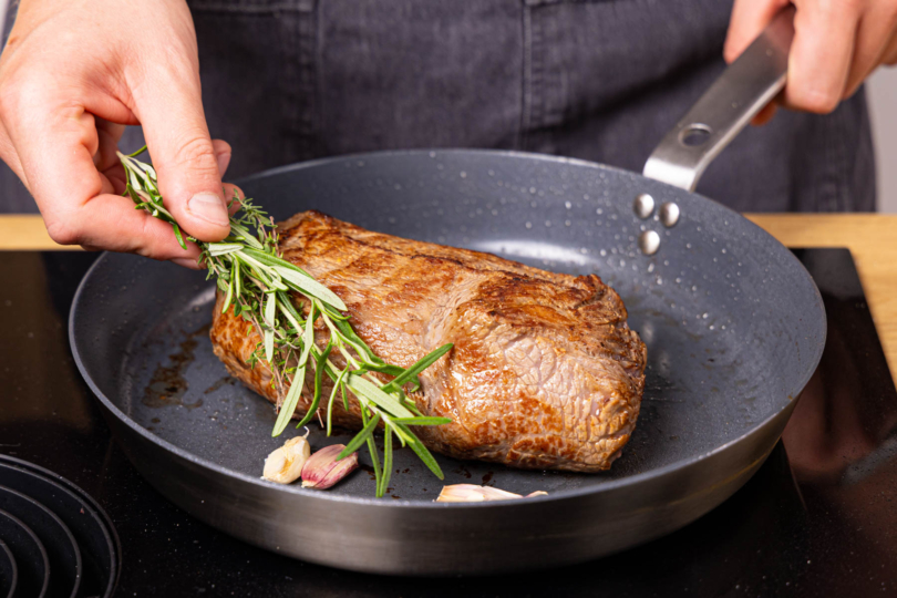 Kräuter und Knoblauch gemeinsam mit Roastbeef braten
