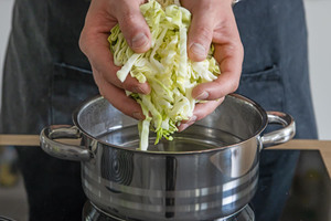 Weißkohl in den Topf geben