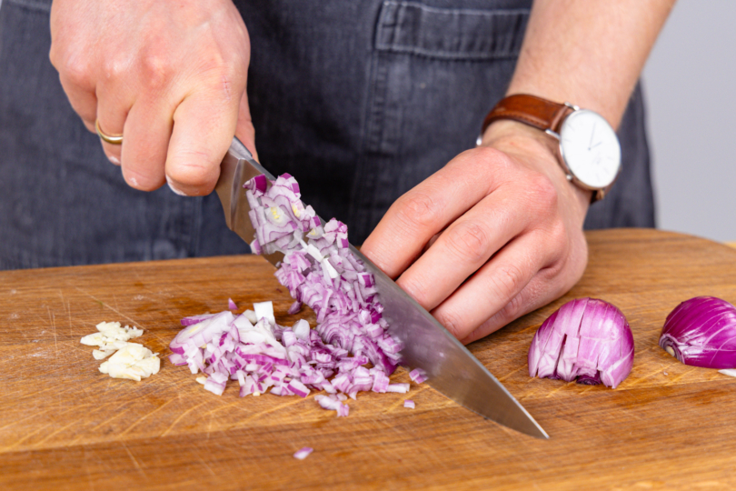 Zwiebel und Knoblauch würfeln