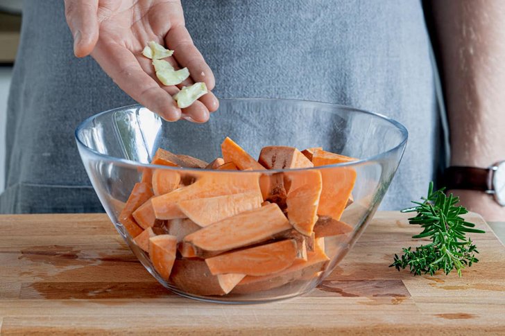 Knoblauch zu den Süßkartoffeln geben