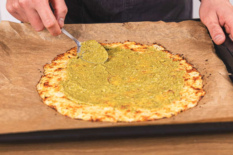 Blumekohlpizza mit Pesto bestreichen