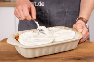 Frischkäsecreme auf der Lasagne verteilen