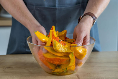Hokkaidokürbis mit Öl und Gewürzen vermengen