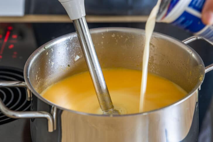 Sahne zur Kürbissuppe geben