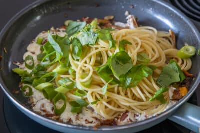 Spaghetti zu gebratenen Pfifferlingen geben