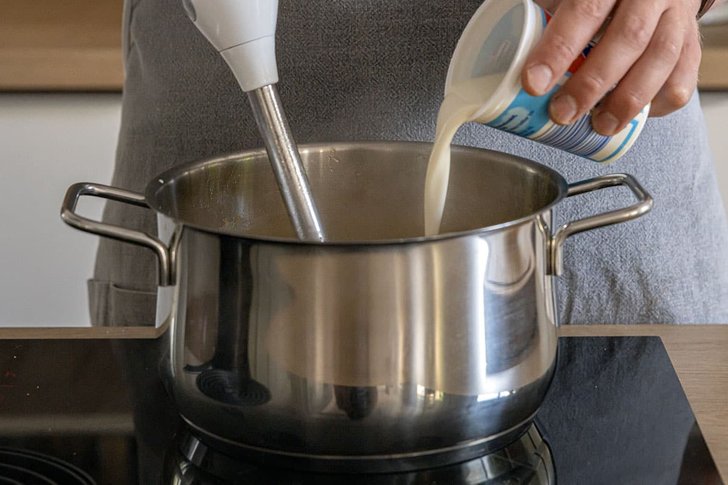 Sahne zur Süßkartoffelsuppe gießen