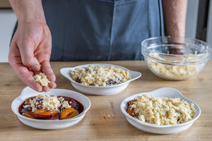 Crumble über Zwetschgen streuen