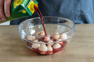 Litschis mit Kirschsaft auffüllen