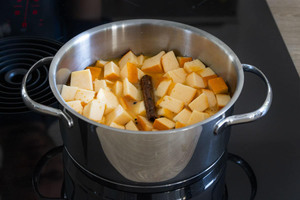 Kürbisstücke mit Orangensaft, Zimt und Vanillemark in einen Topf geben