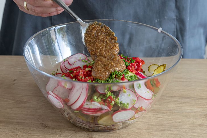 Senf zum Weißwurstsalat geben