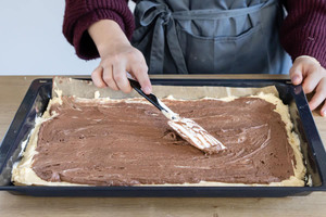 Schokoladenteig auf dem hellen Teig verteilen