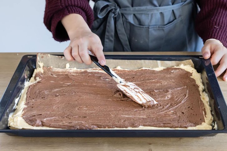 Schokoladenteig auf dem hellen Teig verteilen