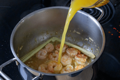 Garnelencurry mit Orangensaft auffüllen