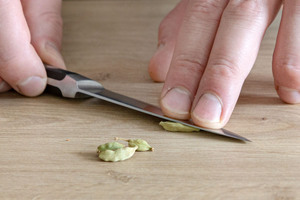 Kardamomkapsel mit dem Messer zerdrücken