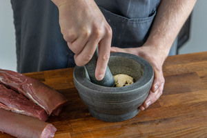 Knoblauch und Gewürze im Mörser zerkleinern