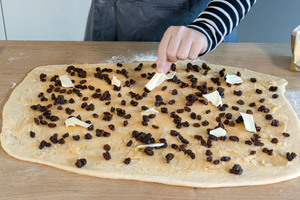 Butterflocken auf Rosinenschnecken verteilen