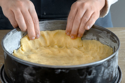 Mürbeteig in die Kuchenform drücken