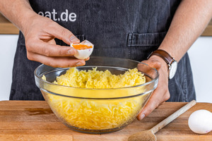 Ei und Eigelb in zerstampfte Kartoffeln untermengen