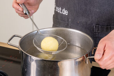 Kartoffelklöße ins Wasser geben