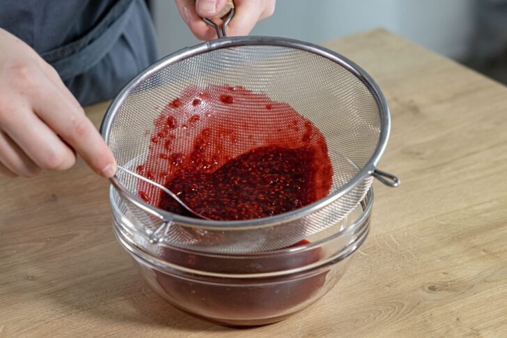 Himbeersauce durch Sieb geben