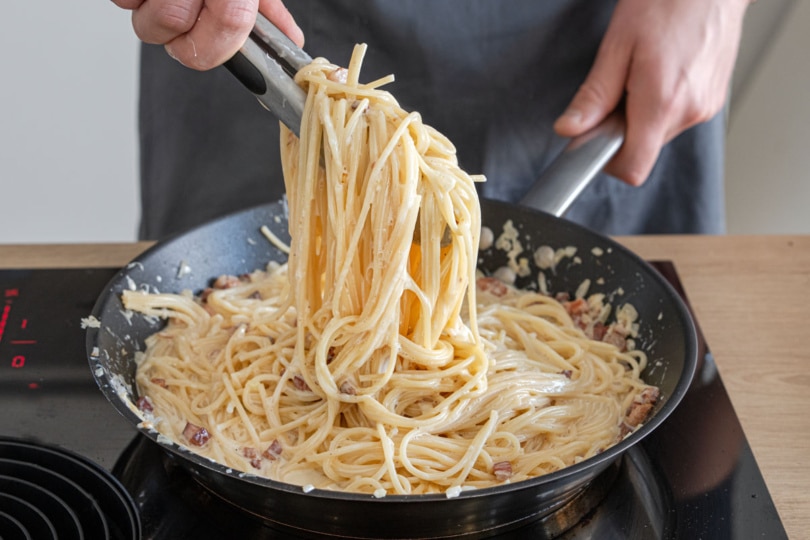 Spaghetti Carbonara mit Sahne durchmischen