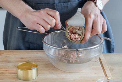 Thunfisch in einem Sieb abtropfen
