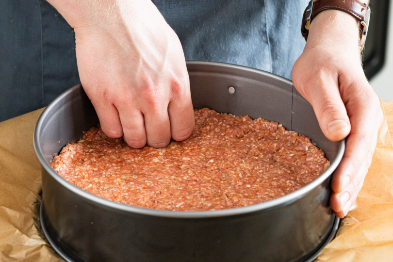 Hackfleisch als Boden in die Springform drücken