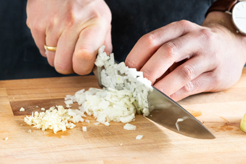 Zwiebeln und Knoblauch in feine Würfel schneiden