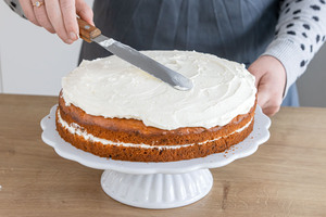 Schmandcreme auf der Möhrentorte verteilen