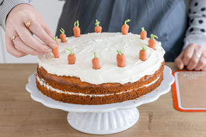 Marzipankarotten auf der Möhrentorte verteilen