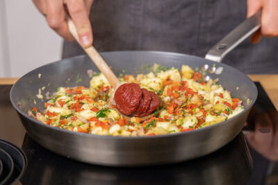Tomatenmark in die Pfanne geben