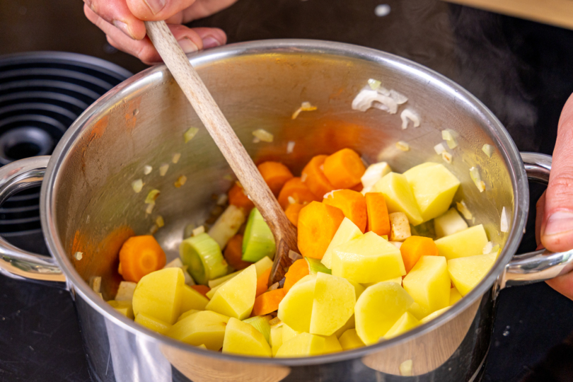 Kartoffeln zum Gemüse in den Topf geben