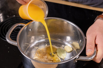 Orangensaft in den Topf gießen