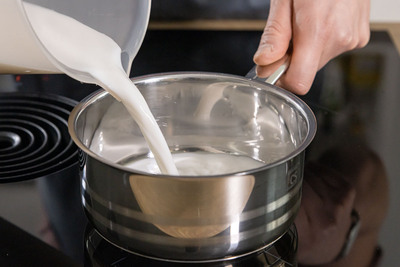 Mandelmilch in den Topf gießen