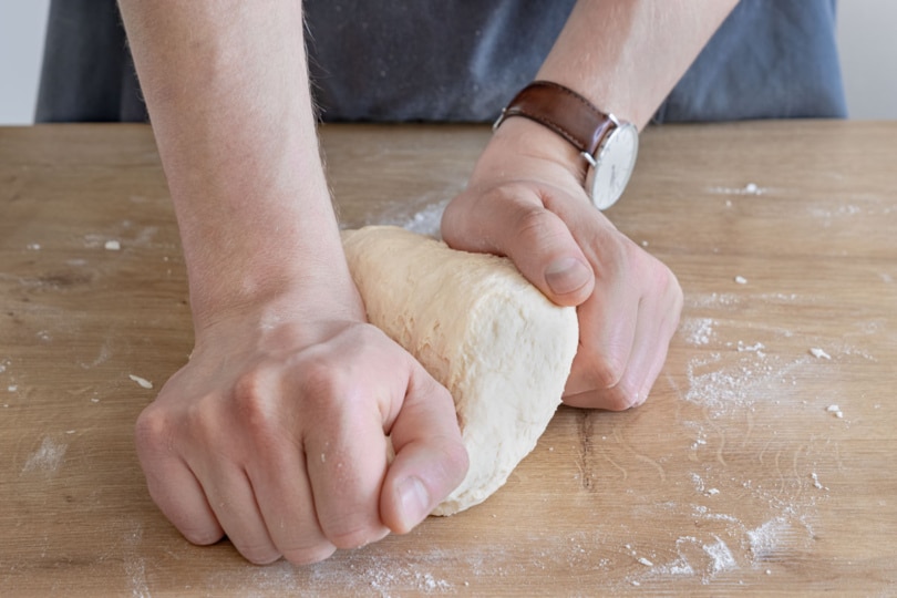 Pizzateig mit den Händen kneten