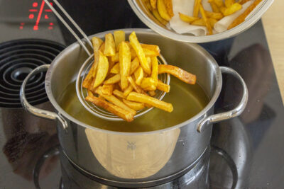 Pommes aus dem Öl holen