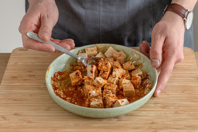 Tofu mit Marinade vermengen