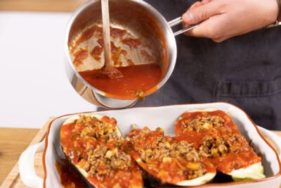 Die Auberginen mit Tomatenesauce übergießen.