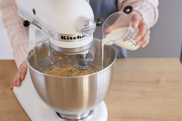 Milch zum Teig für Omas saftigen Nusskuchen geben