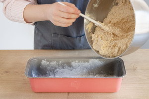 Teig für Omas saftigen Nusskuchen in die Kastenform geben