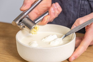 Knoblauch zur Auflaufsoße pressen