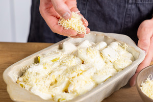 Vegetarischer Spargelauflauf mit Kartoffeln mit Käse bestreuen