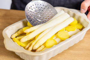 Spargel und Kartoffeln in Auflaufform schichten