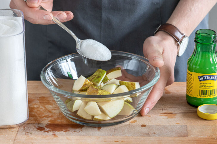 Zucker und Zitronensaft zu Birnen geben